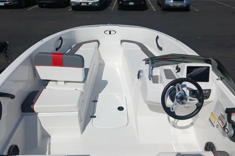 Slide: The Image of 2026 Tahoe T16 boat interior with modern steering and seating in a parking lot. - 4