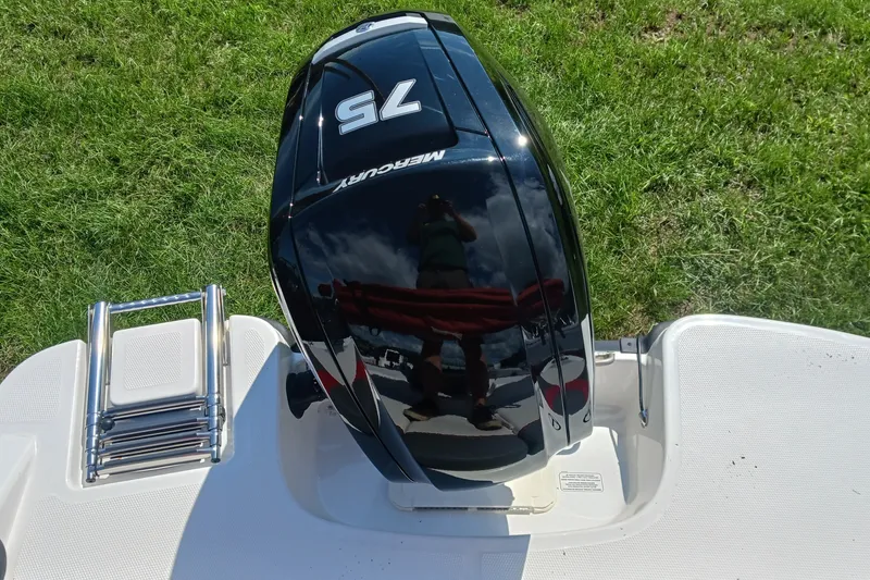 Slide: The Image of Mercury 75 outboard motor on 2026 Tahoe T16 boat, with ladder, on grass background. - 10