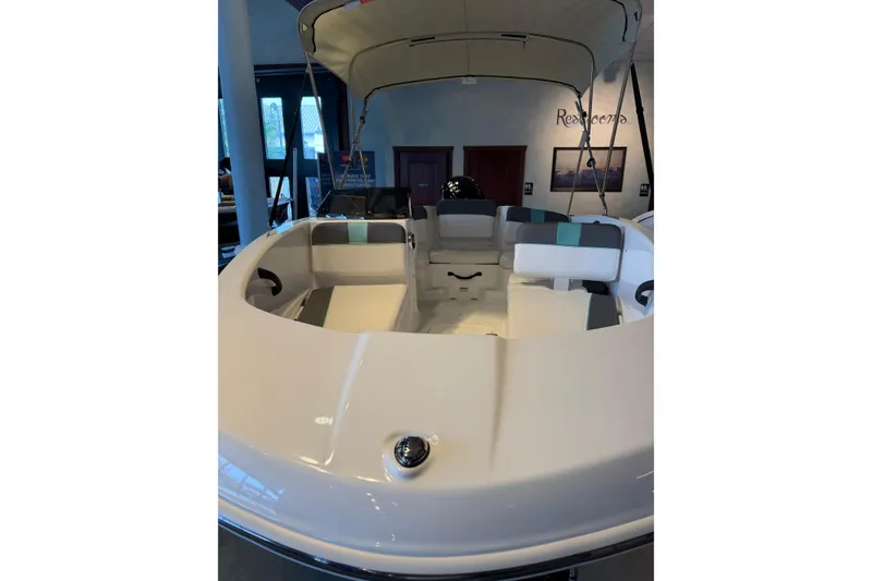 Slide: The Image of 2026 Tahoe T16 boat interior with seating and canopy in showroom. - 4