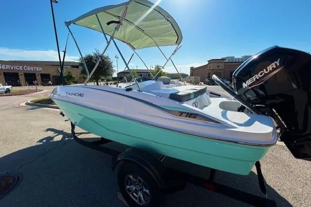 Slide: The Image of 2026 Tahoe T16 boat with canopy and Mercury engine in a parking lot. - 3