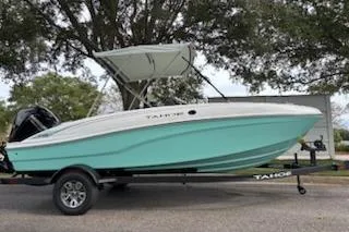 Slide: The Image of 2026 Tahoe T16 boat with canopy on trailer, parked under trees. - 4