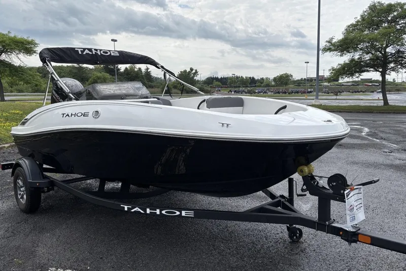 Slide: The Image of 2026 Tahoe T16 boat on trailer in parking lot, overcast sky. - 1