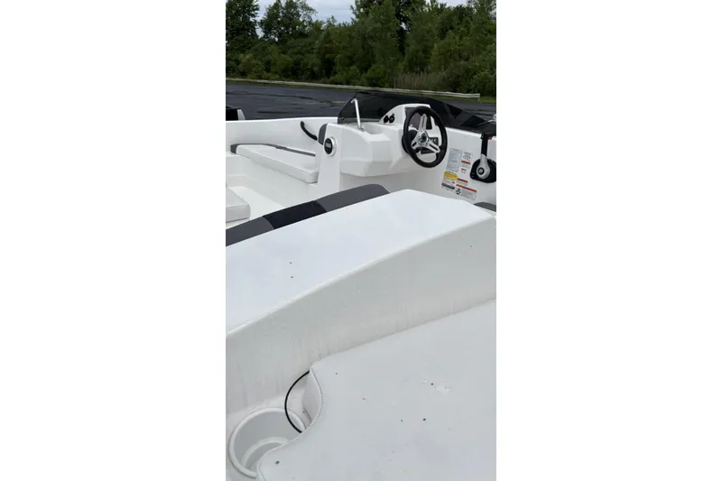 Slide: The Image of 2026 Tahoe T16 boat interior with steering wheel and seating, surrounded by greenery. - 5
