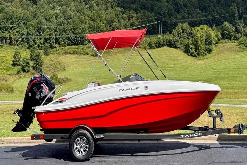 Slide: The Image of 2026 Tahoe T18 boat with red hull and canopy on a trailer. - 2