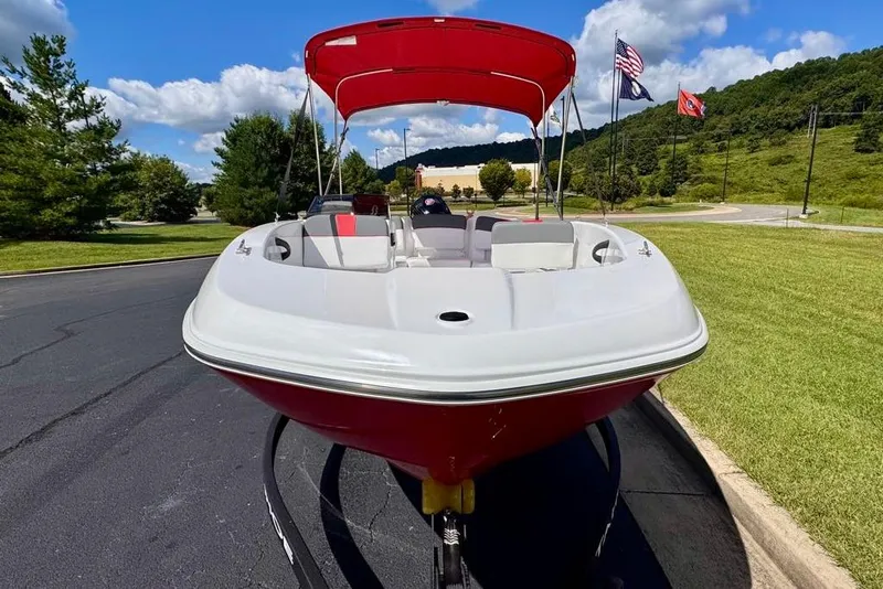 Slide: The Image of 2026 Tahoe T18 boat with red canopy on a sunny day, parked on pavement. - 4