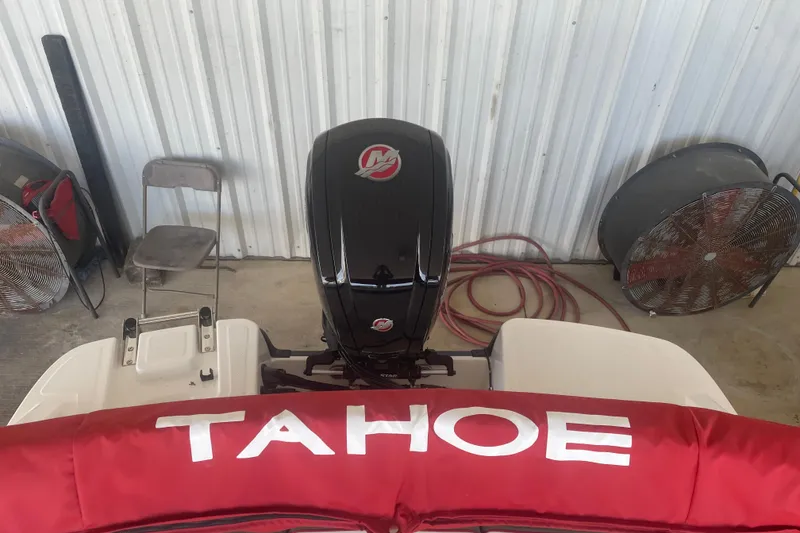 Slide: The Image of 2026 Tahoe T18 boat with red cover and outboard motor in a garage. - 6