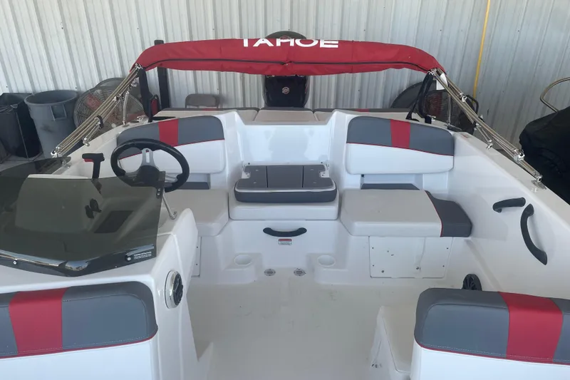 Slide: The Image of 2026 Tahoe T18 boat interior with red and gray seating, steering wheel, and canopy. - 9