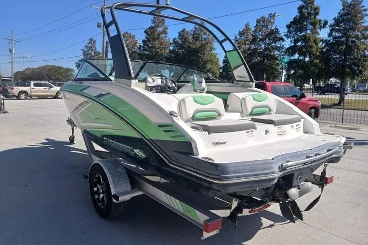 Slide: The Image of 2016 Chaparral Vortex 203 VR boat on trailer, featuring green and white design. - 4