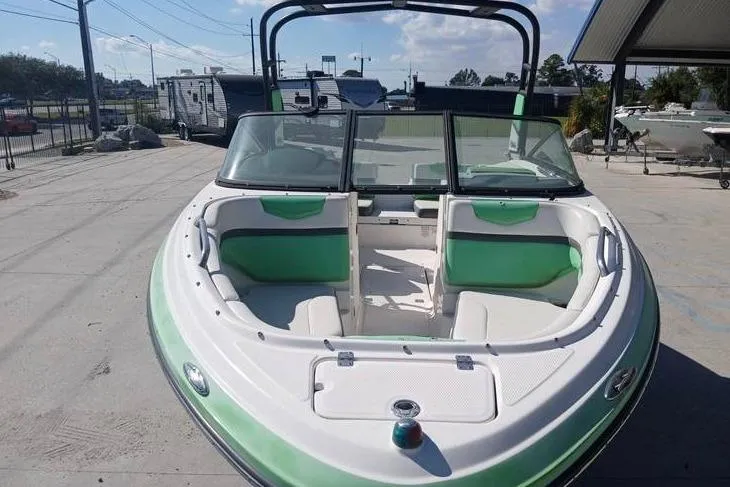 Slide: The Image of 2016 Chaparral Vortex 203 VR boat with green and white interior, docked outdoors. - 7