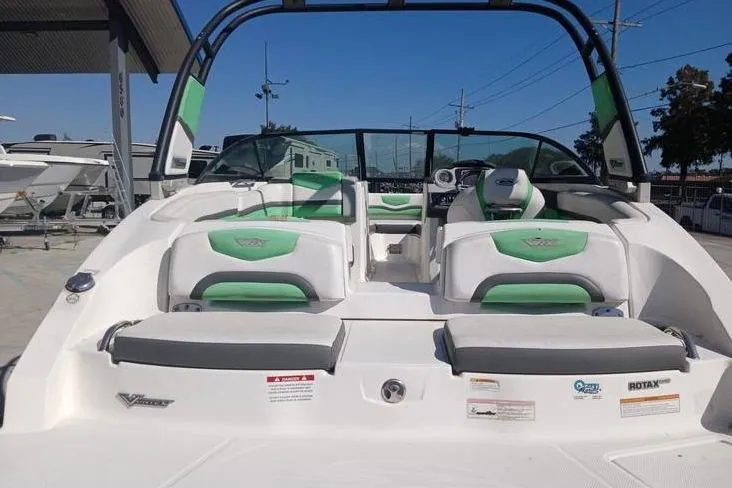 Slide: The Image of 2016 Chaparral Vortex 203 VR boat with green and white seating, docked outdoors. - 8
