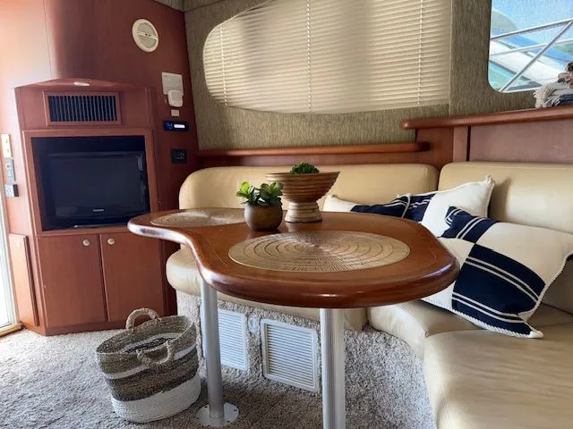 Slide: The Image of Interior of 2004 Silverton 34 Convertible yacht with cozy seating and elegant wooden table. - 16
