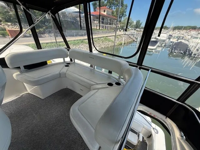 Slide: The Image of 2004 Silverton 34 Convertible yacht interior with white seating and marina view. - 7