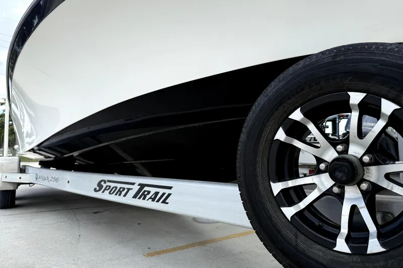 Slide: The Image of 2019 BlackJack 256 boat on Sport Trail trailer, close-up of wheel and hull. - 11