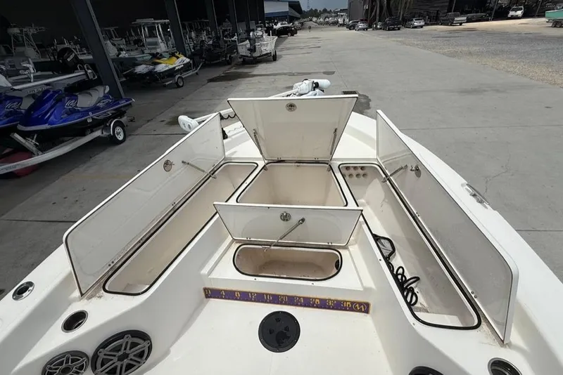 Slide: The Image of Open storage compartments on a 2019 BlackJack 256 boat, docked near jet skis. - 20