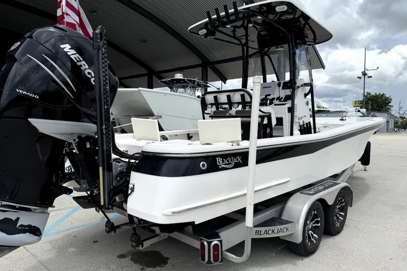 Slide: The Image of 2019 BlackJack 256 boat with Mercury Verado engine on trailer, parked outdoors. - 7