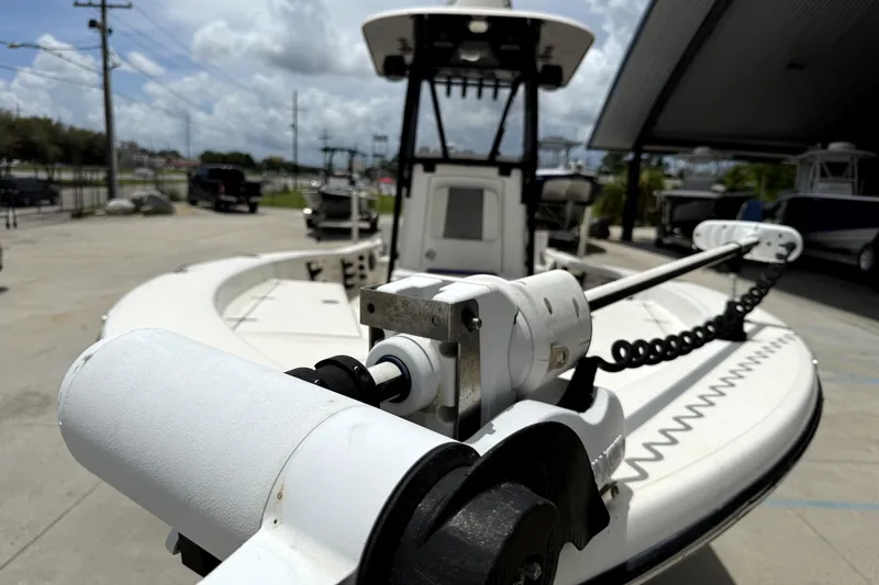 Slide: The Image of 2019 BlackJack 256 boat with trolling motor, parked outdoors under cloudy sky. - 9