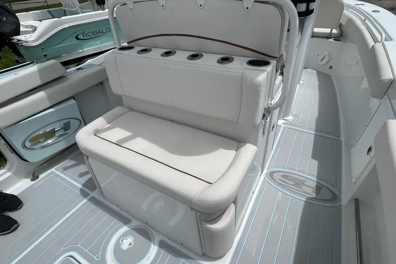 Slide: The Image of 2020 Sea Hunt Ultra 275 SE boat interior with cushioned seating and cup holders. - 13