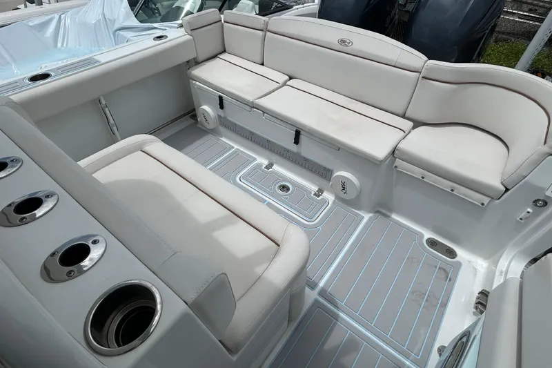 Slide: The Image of 2020 Sea Hunt Ultra 275 SE boat interior with cushioned seating and cup holders. - 15