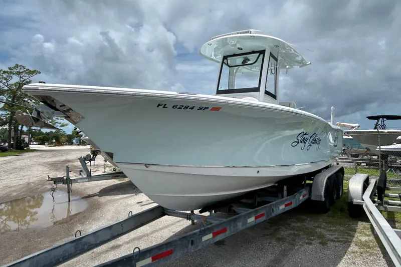 Slide: The Image of 2020 Sea Hunt Ultra 275 SE boat on trailer, parked outdoors under cloudy sky. - 4