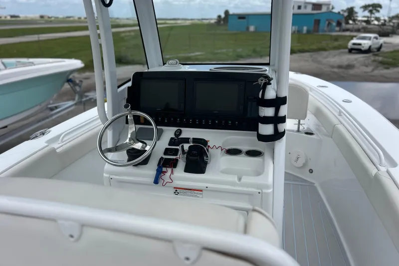 Slide: The Image of 2020 Sea Hunt Ultra 275 SE boat dashboard with steering wheel and navigation screens. - 7