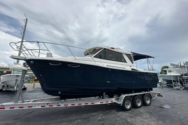 Slide: The Image of 2020 Cutwater C-28 boat on trailer, displayed outdoors under cloudy sky. - 11
