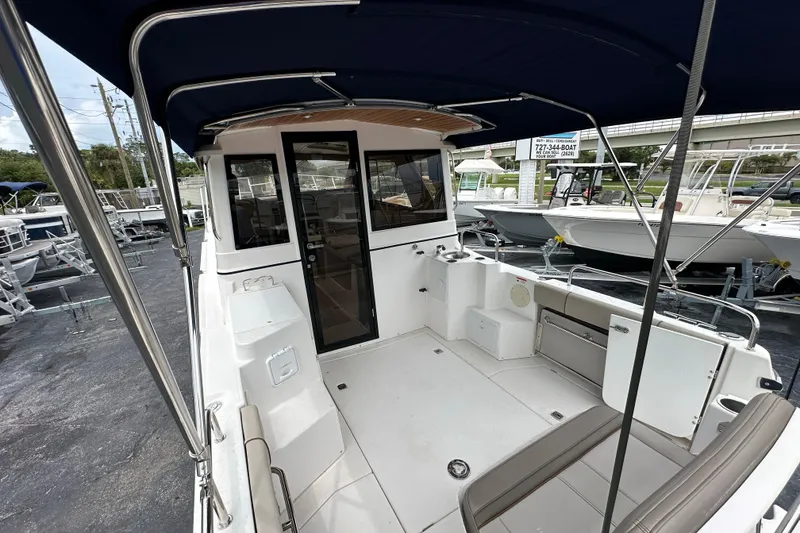 Slide: The Image of 2020 Cutwater C-28 boat interior with seating and canopy, docked at a marina. - 12