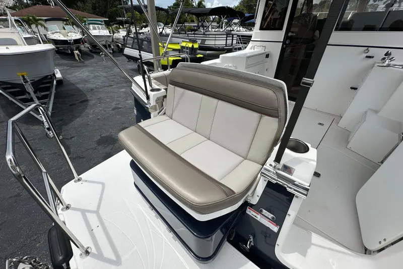 Slide: The Image of 2020 Cutwater C-28 boat with cushioned seating on deck, surrounded by other boats. - 15