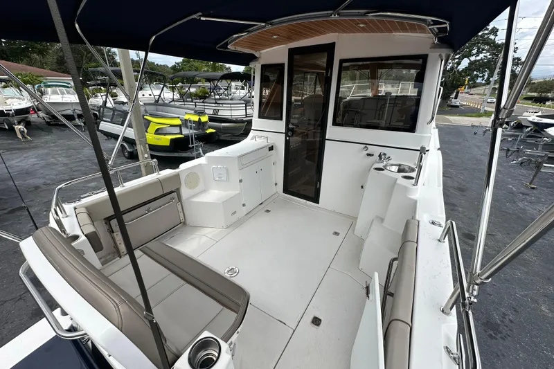 Slide: The Image of 2020 Cutwater C-28 boat interior with seating and sink, docked at a marina. - 16