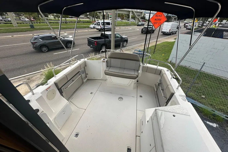 Slide: The Image of 2020 Cutwater C-28 boat interior with seating, parked near a busy road. - 21