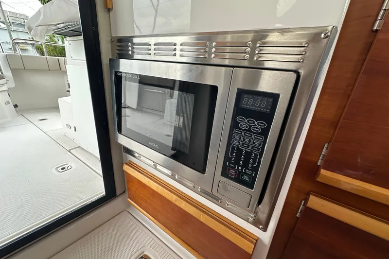 Slide: The Image of 2020 Cutwater C-28 boat interior with built-in microwave and wooden cabinetry. - 25