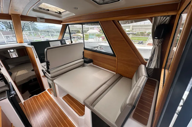 Slide: The Image of Interior of 2020 Cutwater C-28 boat with seating, wood accents, and Garmin navigation system. - 27