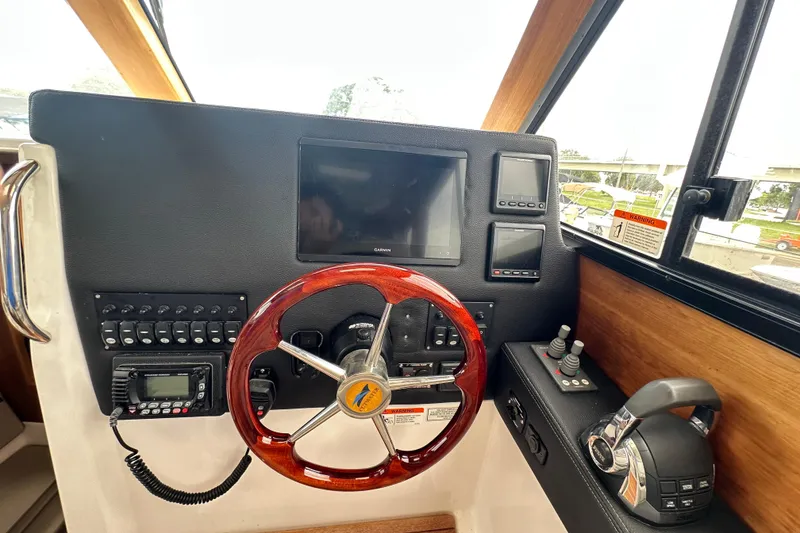 Slide: The Image of Helm of 2020 Cutwater C-28 boat with steering wheel, controls, and navigation screens. - 29