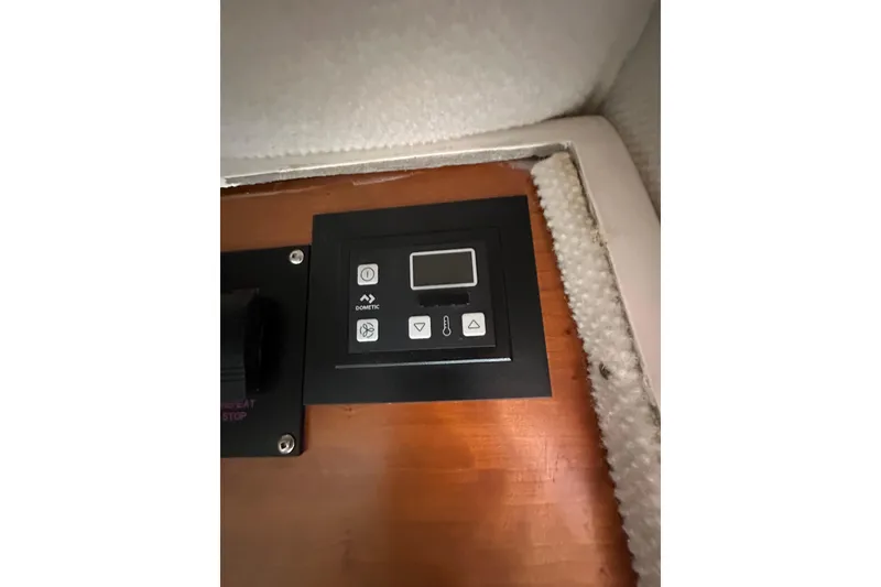 Slide: The Image of Control panel inside 2020 Cutwater C-28 boat, featuring Dometic interface on wooden surface. - 36