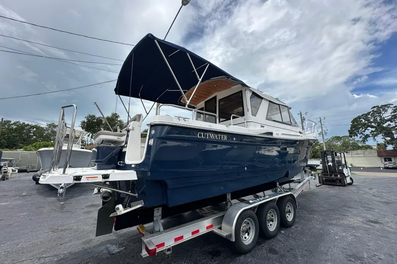 Slide: The Image of 2020 Cutwater C-28 boat on trailer, blue hull, canopy, outdoor setting. - 4