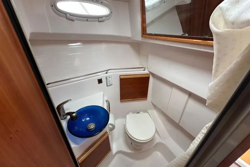 Slide: The Image of 2020 Cutwater C-28 boat bathroom with blue sink, toilet, and wooden accents. - 41