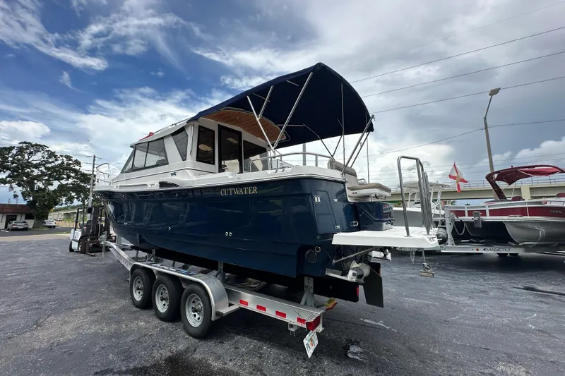 Slide: The Image of 2020 Cutwater C-28 boat on trailer, blue hull, parked outdoors under cloudy sky. - 8