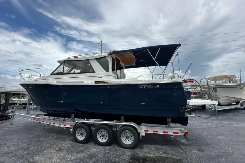 Slide: The Image of 2020 Cutwater C-28 boat on a trailer, under a cloudy sky. - 9