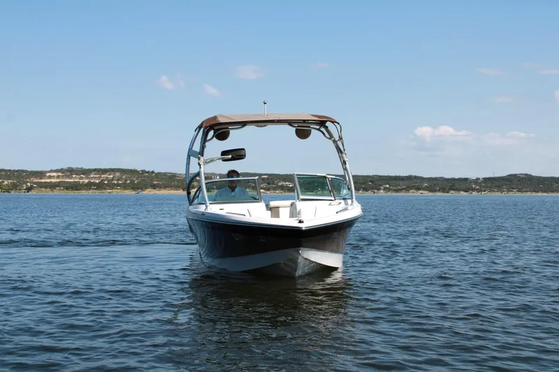 Slide: The Image of 2008 Air Nautique Crossover 236 boat on a calm lake under clear skies. - 10