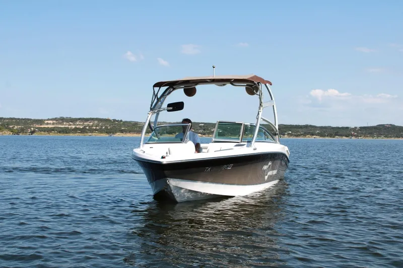 Slide: The Image of 2008 Air Nautique Crossover 236 boat on a calm lake under clear skies. - 11