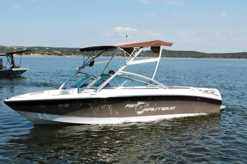 Slide: The Image of 2008 Air Nautique Crossover 236 boat on a calm lake with a canopy. - 14