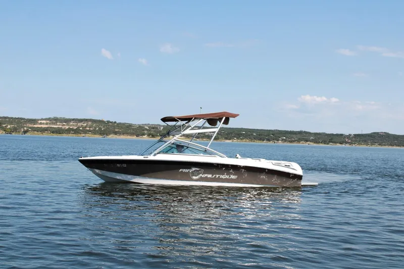 Slide: The Image of 2008 Air Nautique Crossover 236 boat on a calm lake under clear skies. - 15