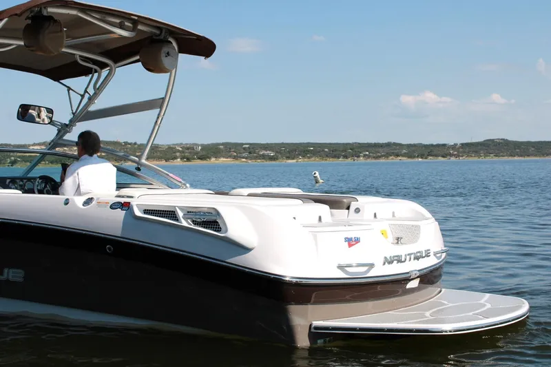 Slide: The Image of 2008 Air Nautique Crossover 236 boat on a calm lake with scenic background. - 18