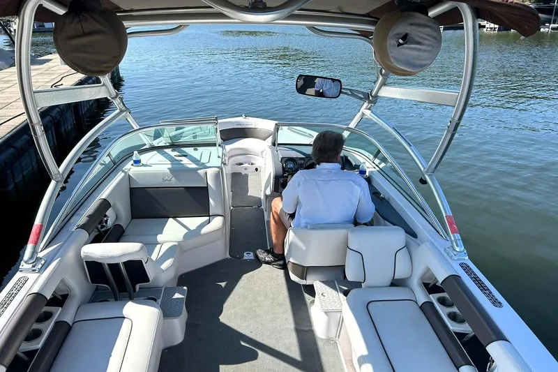 Slide: The Image of 2008 Air Nautique Crossover 236 boat interior with driver on calm water. - 25