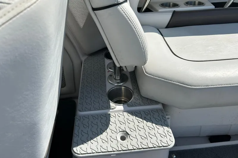 Slide: The Image of 2008 Air Nautique Crossover 236 interior with gray seating and cup holders. - 31