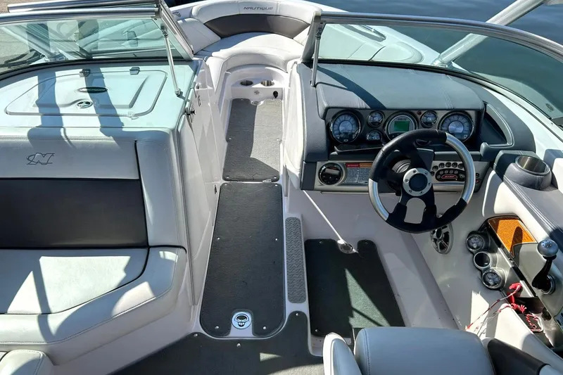 Slide: The Image of 2008 Air Nautique Crossover 236 boat interior with steering wheel and dashboard controls. - 36