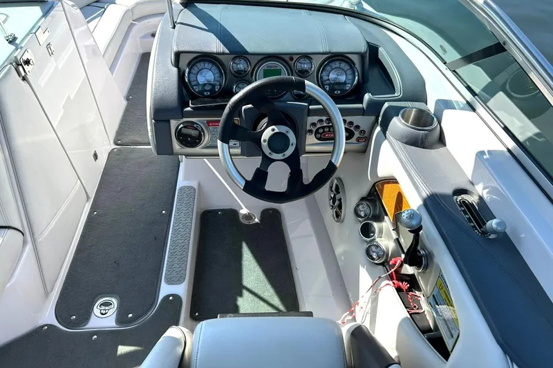 Slide: The Image of 2008 Air Nautique Crossover 236 boat cockpit with steering wheel and control panel. - 37