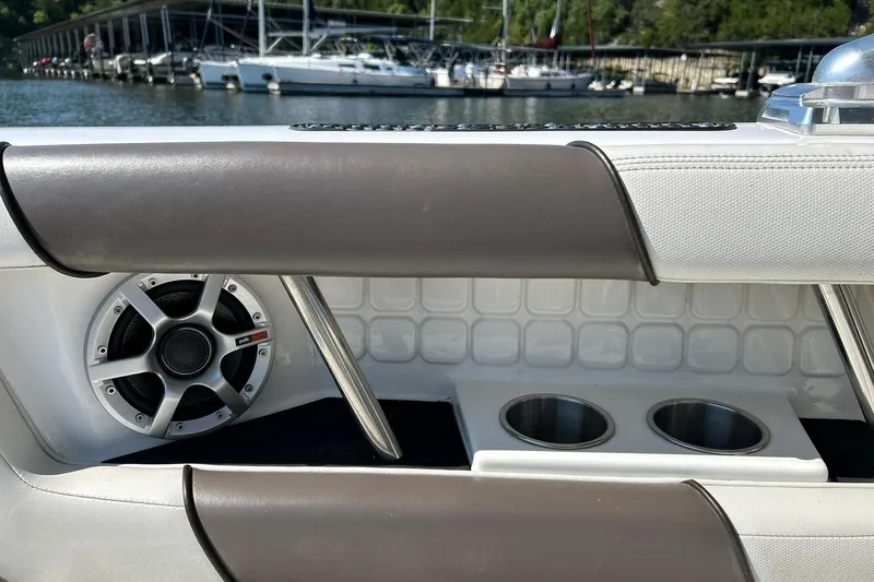 Slide: The Image of 2008 Air Nautique Crossover 236 interior with speaker and cup holders, docked by marina. - 49