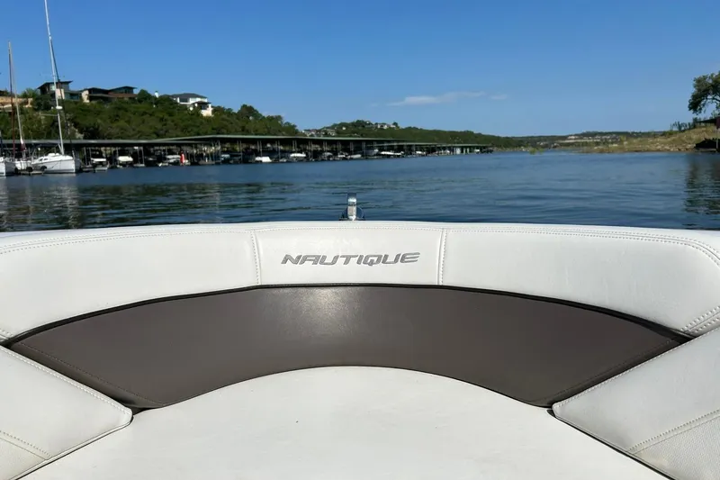 Slide: The Image of 2008 Air Nautique Crossover 236 boat on a serene lake with clear blue skies. - 52
