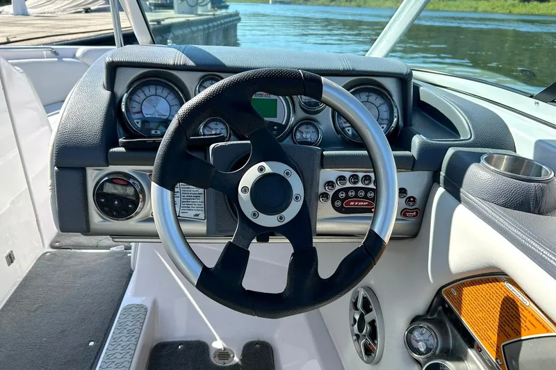 Slide: The Image of 2008 Air Nautique Crossover 236 boat dashboard with steering wheel and control panel. - 6