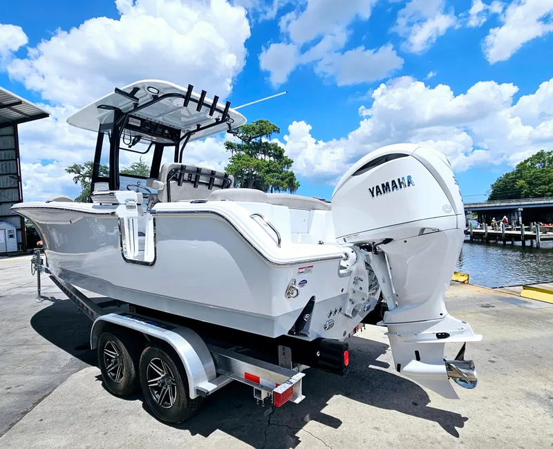 Slide: The Image of 2025 Sea Hunt Ultra 255 SE boat with Yamaha engine on trailer, under blue sky. - 47